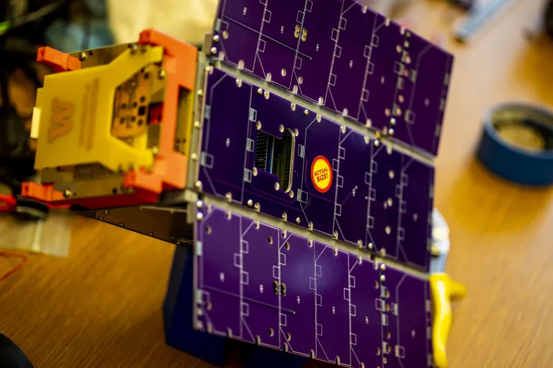 An earlier model of the satellite, shown here in the lab, had solar panels on wings that unfold. 